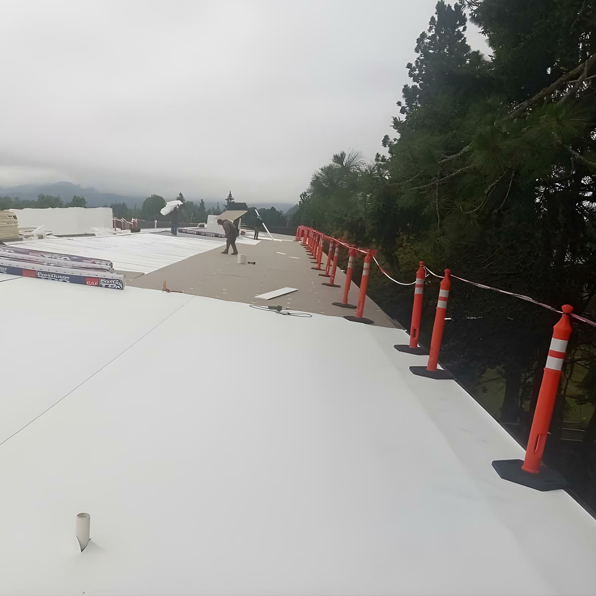 Commercial flat roof under construction with bollards.